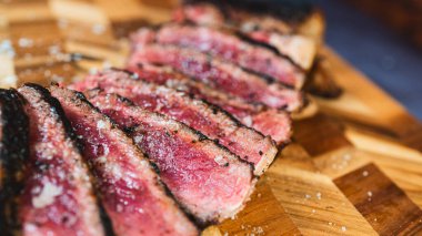 Biftek az pişmiş, dilimlenmiş, mükemmel pembe bir iç ve koyu, ızgara bir dış yüzeyi ortaya çıkarmak için. Etseverler ve gurme yemekler için yumuşak, sulu ve güzel bir sunum..