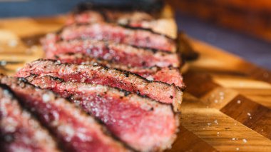 Biftek az pişmiş, dilimlenmiş, mükemmel pembe bir iç ve koyu, ızgara bir dış yüzeyi ortaya çıkarmak için. Etseverler ve gurme yemekler için yumuşak, sulu ve güzel bir sunum..