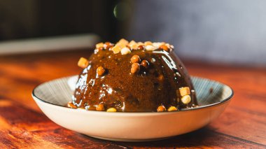 Beautiful sticky pudding drizzled with rich caramel sauce and topped with small fudge pieces. Decadent, warm, and perfect for holiday desserts or indulgent sweet treats.