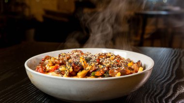 Susam tohumlu, taze sebzeli, dumanı üstünde güzel bir biftek udon kasesi. Zengin et suyu, taze sığır eti ve canlı renkler. Japon yemek severler için mükemmel..