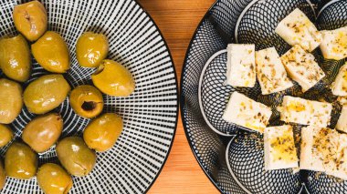 İçinde zeytinler, battaniyeli domuzlar, Asya sebzeli börekler ve çeşitli peynirler olan güzel bir abur cubur tahtası. Paylaşmak, partiler ve günlük eğlence için mükemmel. Renkli ve davetkar.