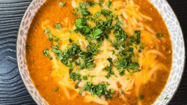 Erimiş peynir ve taze soğanla kaplı kalın, nefis sığır güveci. Zengin, rahatlatıcı ve lezzet dolu. Soğuk günler ve ev yapımı yemekler için mükemmel..