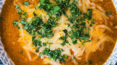 Erimiş peynir ve taze soğanla kaplı kalın, nefis sığır güveci. Zengin, rahatlatıcı ve lezzet dolu. Soğuk günler ve ev yapımı yemekler için mükemmel..