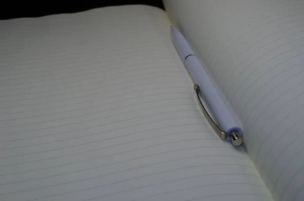 打开的笔记本的顶视图与笔在灰色的背景 学校笔记本与螺旋弹簧 办公室记事本平躺 — 图库照片