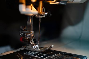 İğneye iliştirilmiş iplik içeren ayak dikiş makinesi