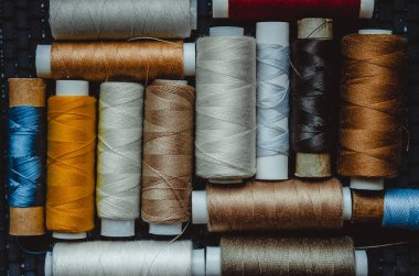 Retro dikiş malzemeleri: terzi makası, kesme bıçağı, yüksük, ahşap iplik makaraları, iğne, kumaş ve dikiş aksesuarları da dahil olmak üzere yastık.