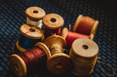 Retro dikiş malzemeleri: terzi makası, kesme bıçağı, yüksük, ahşap iplik makaraları, iğne, kumaş ve dikiş aksesuarları da dahil olmak üzere yastık.