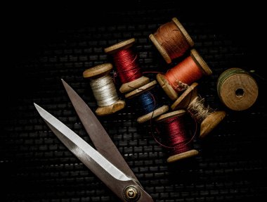 Retro dikiş malzemeleri: terzi makası, kesme bıçağı, yüksük, ahşap iplik makaraları, iğne, kumaş ve dikiş aksesuarları da dahil olmak üzere yastık.