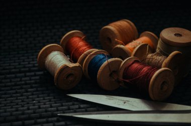 Retro dikiş malzemeleri: terzi makası, kesme bıçağı, yüksük, ahşap iplik makaraları, iğne, kumaş ve dikiş aksesuarları da dahil olmak üzere yastık.