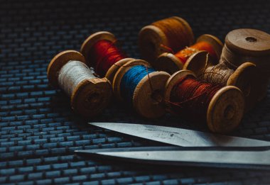 Retro dikiş malzemeleri: terzi makası, kesme bıçağı, yüksük, ahşap iplik makaraları, iğne, kumaş ve dikiş aksesuarları da dahil olmak üzere yastık.