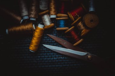 Retro dikiş malzemeleri: terzi makası, kesme bıçağı, yüksük, ahşap iplik makaraları, iğne, kumaş ve dikiş aksesuarları da dahil olmak üzere yastık.