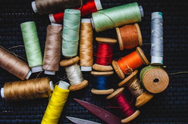 Retro dikiş malzemeleri: terzi makası, kesme bıçağı, yüksük, ahşap iplik makaraları, iğne, kumaş ve dikiş aksesuarları da dahil olmak üzere yastık.