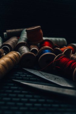 Retro dikiş malzemeleri: terzi makası, kesme bıçağı, yüksük, ahşap iplik makaraları, iğne, kumaş ve dikiş aksesuarları da dahil olmak üzere yastık.