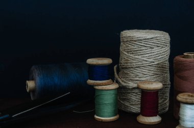 Retro dikiş aletleri: eski makas, gri kumaş üzerindeki iplik bobinleri. Terzinin masası. Tekstil veya ince kumaş üretimi.