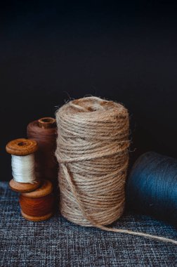 Retro dikiş aletleri: eski makas, gri kumaş üzerindeki iplik bobinleri. Terzinin masası. Tekstil veya ince kumaş üretimi.
