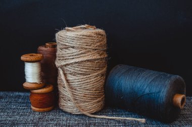Retro dikiş aletleri: eski makas, gri kumaş üzerindeki iplik bobinleri. Terzinin masası. Tekstil veya ince kumaş üretimi.
