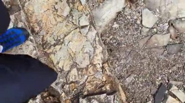 Tortul kayaların üzerinde yürüyen hızlı hareket eden bir adam. Doğa yürüyüşü kavramı, eko turizm macerası. Dikey Video biçimi olarak kullanılabilir.