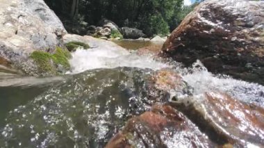 Nehrin kayalıklarından geçen su akıntısının alçak açılı görüntüleri. Doğa su akışı yüzeyde, sığ, kayalara çarpar..