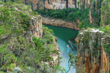 Two tourist boats navigating between the Canyons of Furnas, Capitolio MG Brazil. Landscape of eco tourism of Minas Gerais. Walls of sedimentary rocks and the green water of Lake of Furnas.