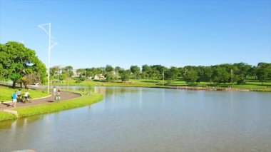Campo Grande - MS, Brezilya - 21 Şubat 2021: Pazar günü Yerli Milletler Parkı, göl manzarası, insanları çalıştırma ve ahşap güverte.