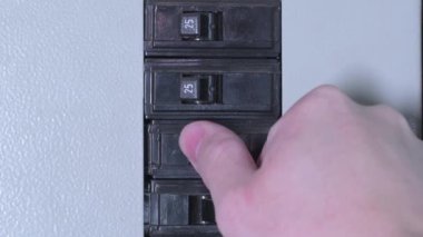 Devre kesici paneldeki bir evin elektriğini açıp kapamak. Elektrik düğmesi açılıp kapanıyor..