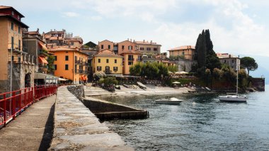Como Gölü 'nün bulutlu ve güneşli bir gününde İtalya' nın Varenna köyü yumuşak güneş ışığıyla