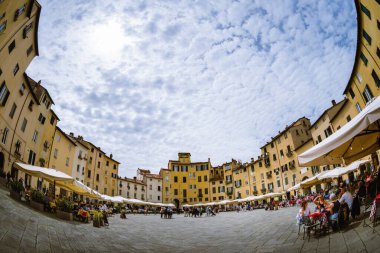 Lucca, İtalya - 23 Mayıs 2021: Lucca, İtalya 'daki Piazza dell' anfiteatro (amphiteater Meydanı) manzarası, Toskana restoranları, masalar ve 23 Mayıs 2021 'de aperitif saatinde bulunan insanlar