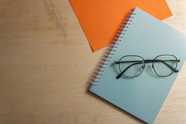 Not Defteri ve Gözlükler Ahşap Masa, İş ve Eğitim konsepti, Üst Görünüm arkaplan.