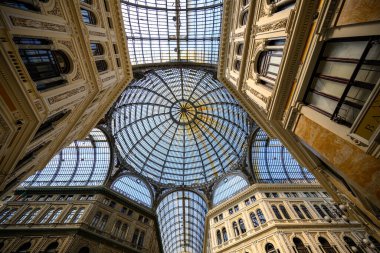 İtalya 'nın Napoli kentinde bulunan Galleria Umberto I, karmaşık işlenmiş demir iskelet tarafından desteklenen süslü cam bir kubbeye sahiptir. Mimari tasarım klasik detaylarla zengindir. Dekoratif kornişler ve pilasterlerle süslenmiş büyük cepheler sergiler.