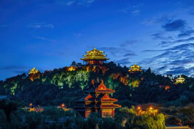 Aydınlatılmış Yasak Şehir Köşesi Kulesi ve Pekin 'deki Jingshan Tepesi' nin gece görüşü geleneksel Çin mimarisi ve şehir ışıklarının sergilendiği.