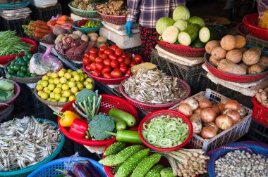 Açık hava pazarında sepetlerde canlı bir sebze çeşidi sergileniyor..