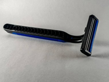 Modern mat siyah arka planda manuel tıraş bıçağı, dokulu ergonomik sapı ve gümüş bıçakları olan profesyonel erkek bakım aracı, şık hijyen ürünü fotoğrafçılığı.