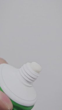 Plastik bir tüpten çıkan beyaz diş macununun yakın plan, detaylı bir videosu. Diş sağlığı, ağız bakımı ve sabah rutin kavramları için idealdir.