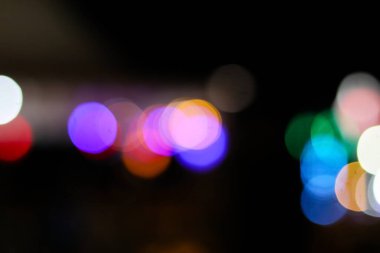 Mor, mavi, pembe ve altın tonlarında yumuşak, bulanık ışık çemberleri (bokeh) içeren canlı bir soyut arkaplan.