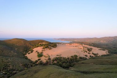 Yeşil tepeler ve Yunanistan 'daki Ege Denizi ile çelişen çorak kum tepeleri