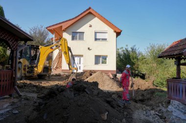 Seyahat Romanya transilvania Targu işçilere zemin hazırlıyor ve ev inşaatı için bir kazıcı kullanıyor