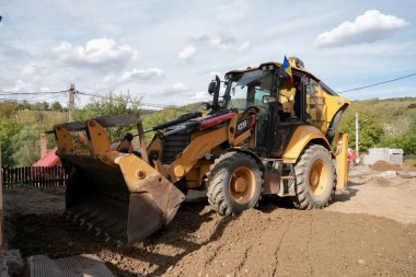 Romanya seyehatine çıkan Transilvanya Targusu, Romanya bayrağını sergileyerek yer hazırlığı üzerinde çalışan kepçe yükleyici yükleyiciyi katletmektedir.