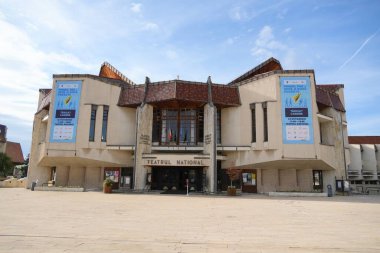 Seyahat Romanya transilvania Targu ulusal tiyatro binası cephesini ve mavi gökyüzünün altındaki asfalt meydanı güder