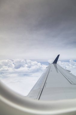 Bulutlarla uçak penceresi görünümü