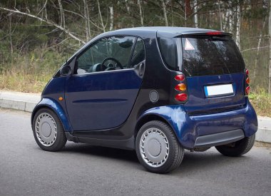 Little blue car driving on the road,  modern city car background