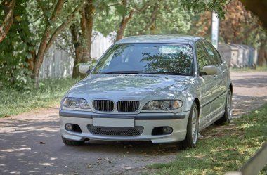 Sokak geçmişi olan beyaz bir araba. Modern şehir fotoğrafı.