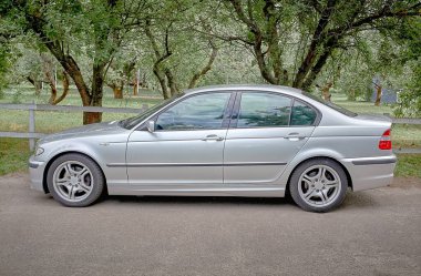 Sokak geçmişi olan beyaz bir araba. Modern şehir fotoğrafı.