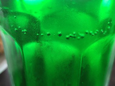 Yeşil cam soyut arkaplan, yakın görüş. Kabarcıklı yeşil sıvı