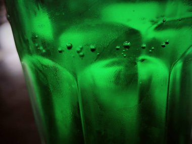 Yeşil cam soyut arkaplan, yakın görüş. Kabarcıklı yeşil sıvı