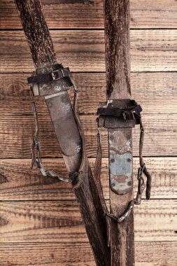 Köhne ahşap arka planda deri kayak bantları olan antik ahşap kayaklar.