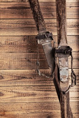 Köhne ahşap arka planda deri kayak bantları olan antik ahşap kayaklar.