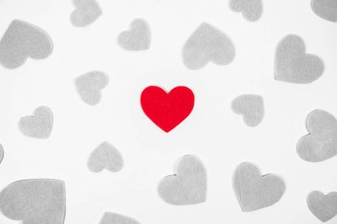Kırmızılı birden fazla gri kalp açık gri arka plana saçılmış..