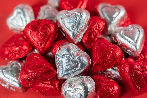 Bir yığın kırmızı ve gümüş folyo paketlenmiş çikolata şekeri.
