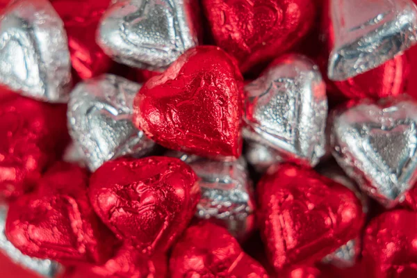 Bir yığın kırmızı ve gümüş folyo paketlenmiş çikolata şekeri.
