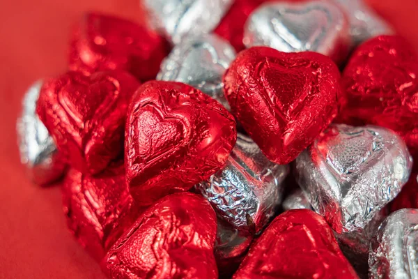 Bir yığın kırmızı ve gümüş folyo paketlenmiş çikolata şekeri.